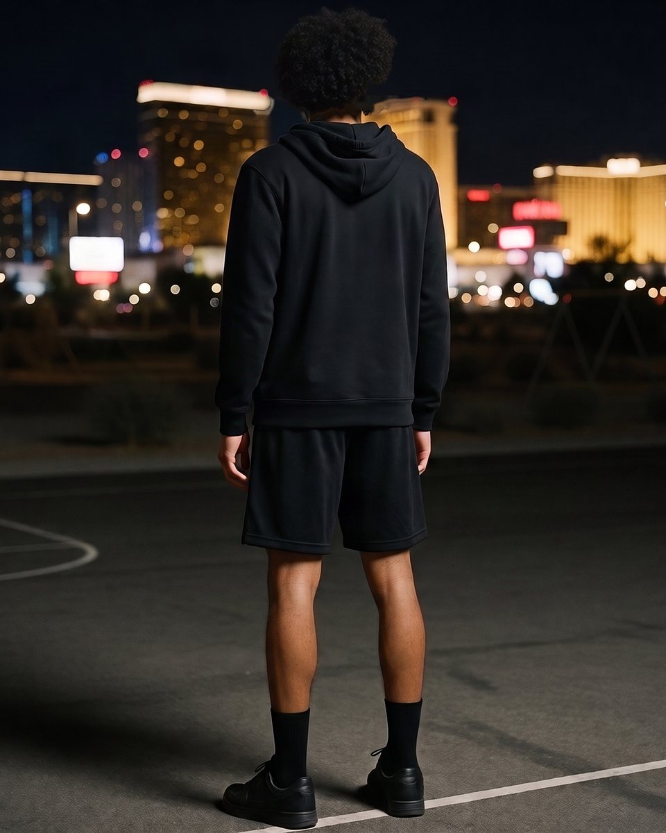The same court, hood down, his curly afro against the city lights